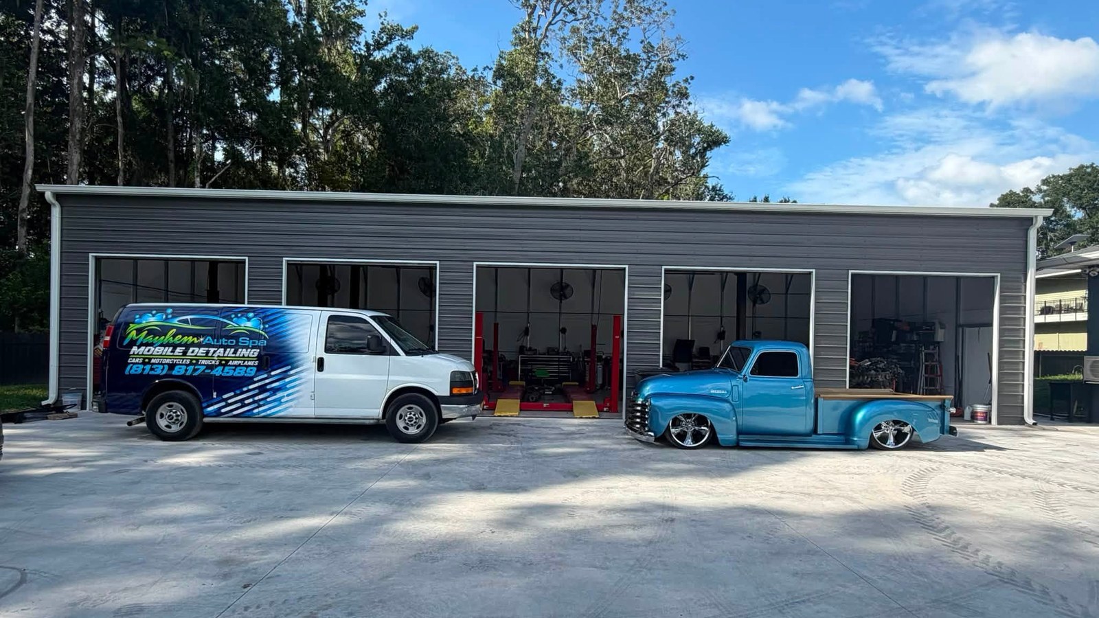 Import Mayhem repair shop in Land O’ Lakes with the Mayhem Auto Spa van and a blue pickup outside.