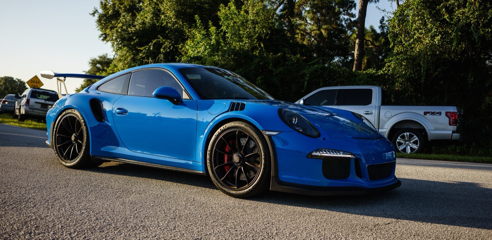 Blue Porsche 911 GT3 RS parked on a Florida road at sunset